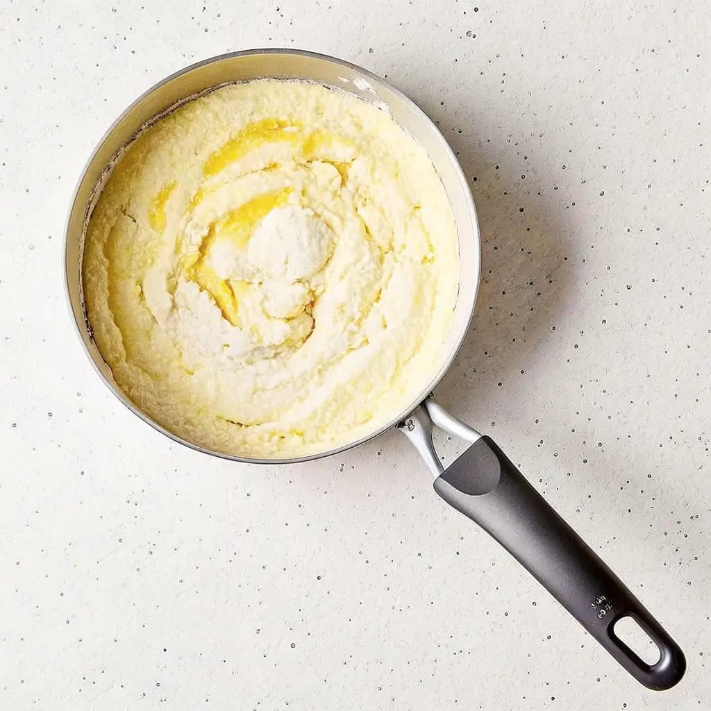 Cremige Béchamelsoße anrühren: Butter, Mehl und Milch zu einer seidig glatten Sauce verrührt im Topf – perfekt für Pastizio, Lasagne oder Gratin.