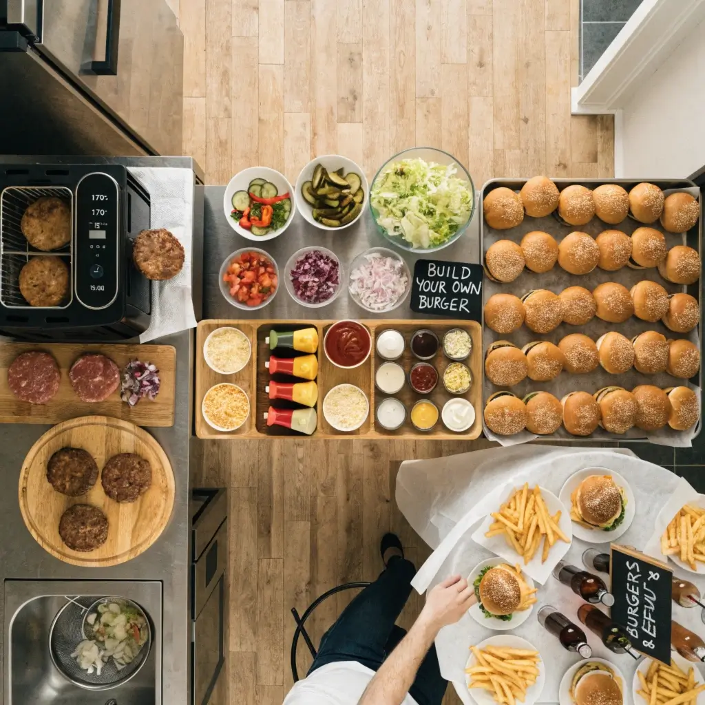 Die Flow-Strategie im Küchenlayout: Übersichtliches Burgerbuffet mit Airfryer, Prep-Station, Toppings und Essbereich aus der Vogelperspektive